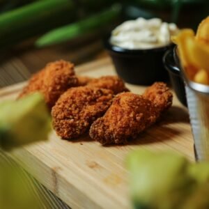 pan fried wings in the wooden board with french fries sauce side view